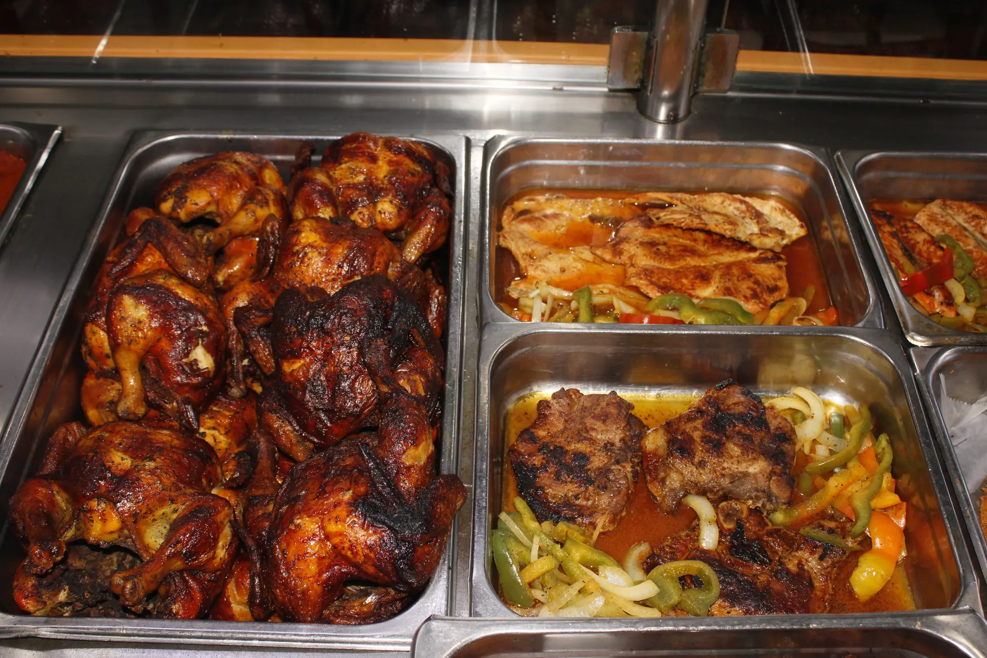 Rotisserie chickens next to pork chops