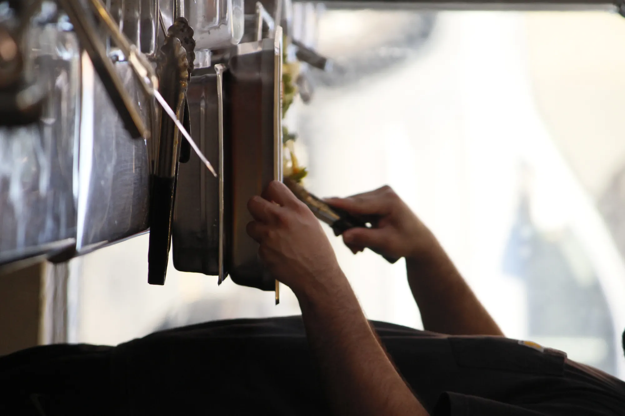 Cook reaching for tongs