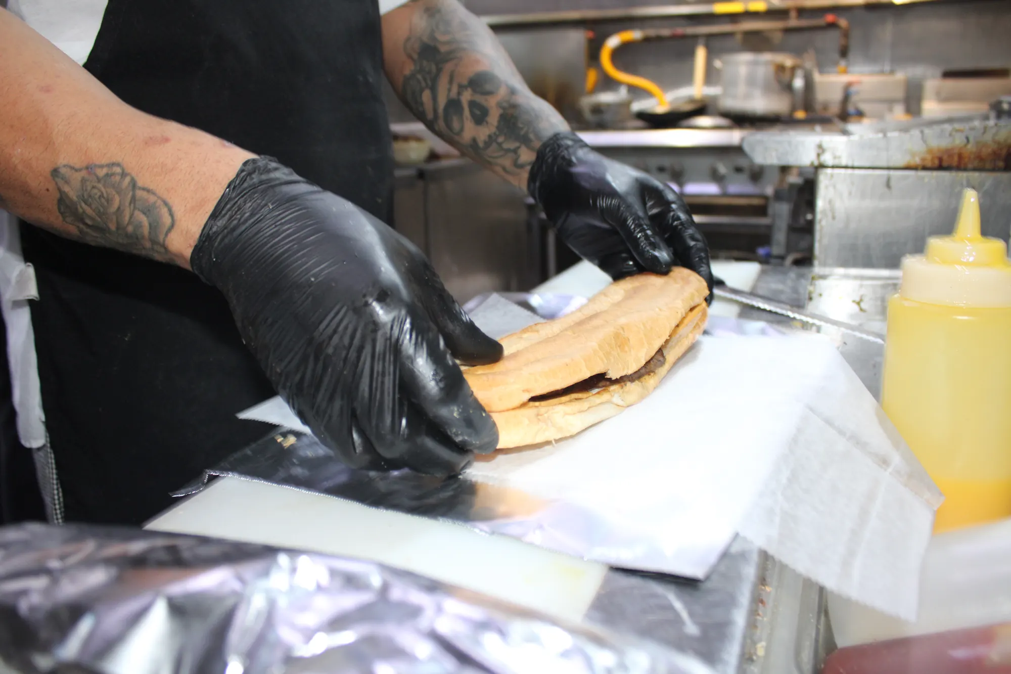 A burger being wrapped in paper and foil, four quick frames